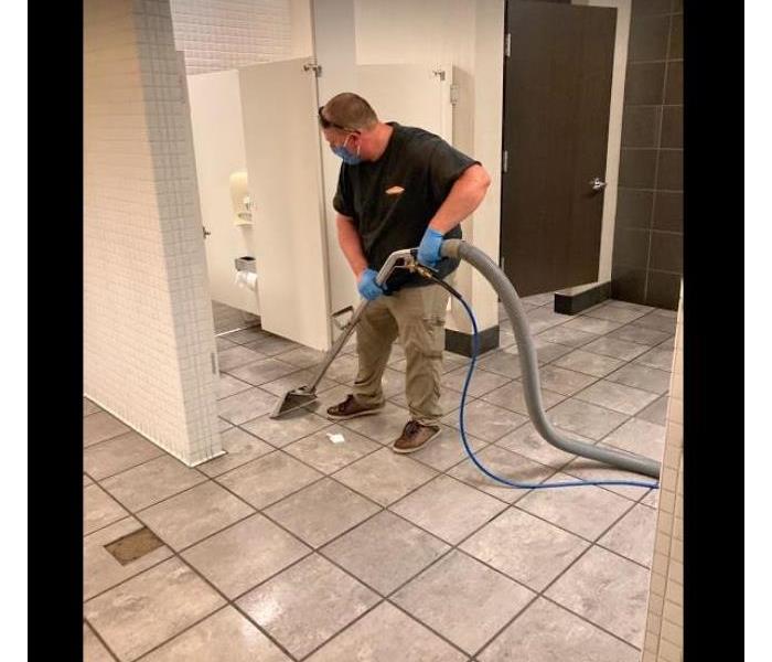 crew member extracting water from commercial bathroom