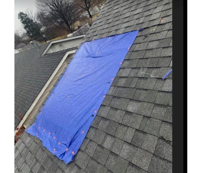 blue tarp on roof of home
